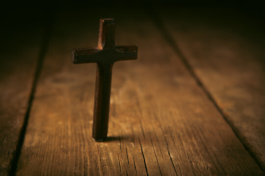 Old wooden cross on a rustic wooden background. Religion concept.