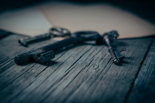 Old keys and envelope on wooden background. Photo in old color image style.