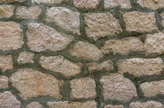 Fresh cement in a natural stone wall that has just been renovated.