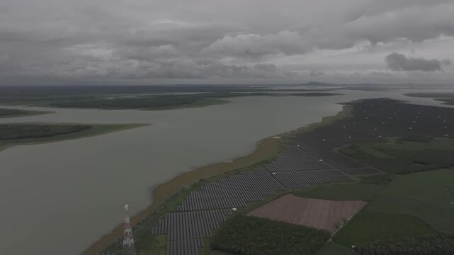 Aerial drone view of a solar power farm on Dau Tieng Lake, Tay Ninh, Vietnam, showcasing photovoltaic panels, renewable energy and sustainable technology across a vast lake landscape.