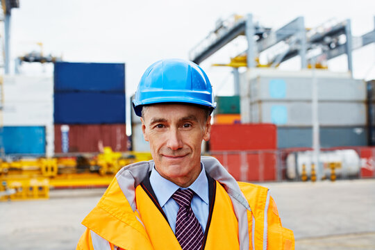 Logistics, portrait or mature man in yard with smile, dispatch worker or about us in distribution. PPE, happy or supplier outdoor with confidence, shipyard coordinator or pride in supply chain career