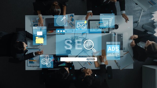 Business Meeting on Digital Marketing Strategy Featuring SEO, Ads, and E-commerce Concepts with Professionals Collaborating Over a Table. Entropy.