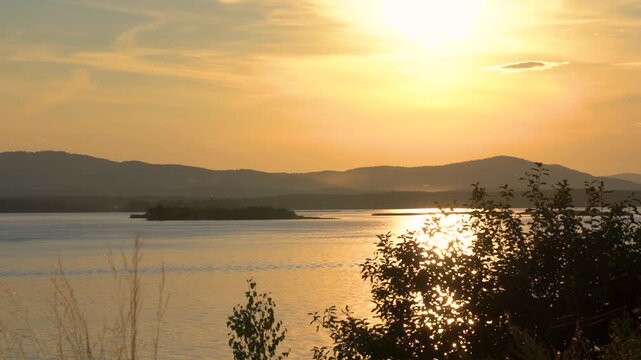 A Serene Evening at the Lake: Captivating Sunset Reflections Over Waters and Silhouetted Hills in a Tranquil Natural Landscape