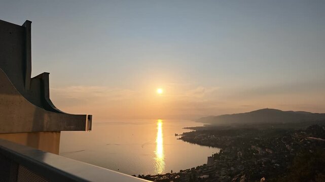 Incredible sunset view looking over the calm, sunlit, waters of Lake Geneva in Montreux, Switzerland.