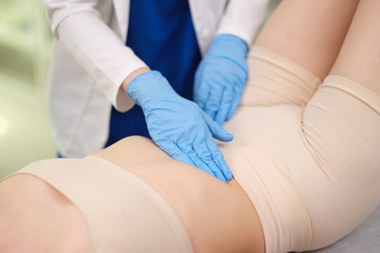 Doctor in gloves performing abdominal examination and palpates abdomen to diagnose appendicitis closeup. Peritoneal symptoms acute abdominal pain
