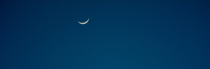 Thin crescent moon and bright planet star in clear blue twilight sky © Ilham