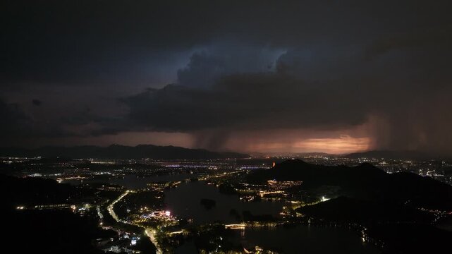 City lights and dark storm clouds at night