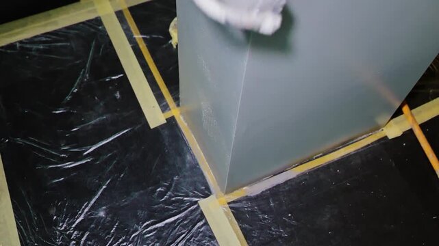 Careful edge painting protects floor with masking tape during indoor renovation