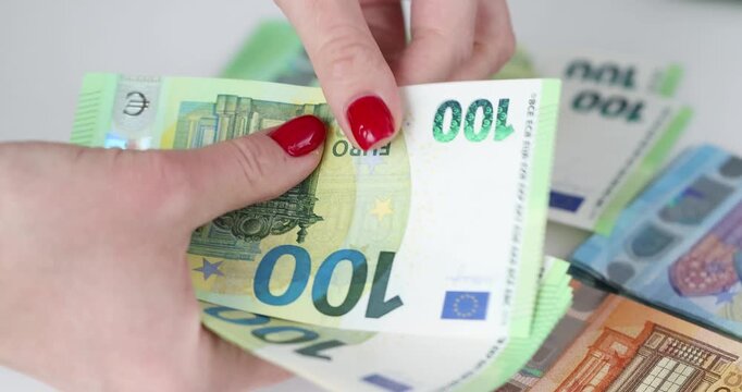 Hands skillfully arrange crisp euro notes, creating a colorful display of wealth. The atmosphere buzzes with energy as bills are counted and organized methodically.