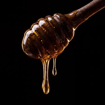 Golden Honey Dripping From Wooden Dipper Isolated Black