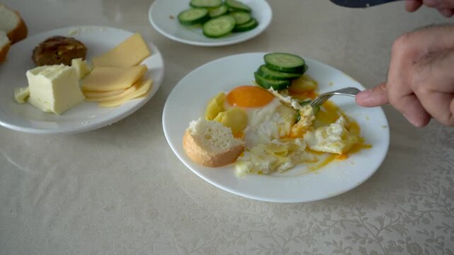 A Close-Up of a Breakfast Plate with Sliced Cucumbers, Egg Yolk, and Bread, Capturing a Flavorful Morning Meal Atmosphere