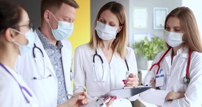 A dedicated team of healthcare professionals discusses patient cases in a bright clinic. Their focus and teamwork highlight the importance of collaboration in medicine.