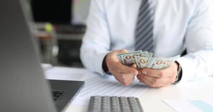 Hands carefully sort through fresh hundred-dollar bills, symbolizing diligence and ambition. A laptop and calculator sit nearby, emphasizing the financial focus in the airy office.
