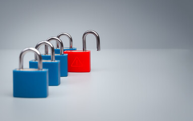 Red unlocked padlock with triangle warning symbol stands among secure blue locks with copy space, illustrating a single point of failure, cybersecurity vulnerability and enterprise risk concept. © tete_escape