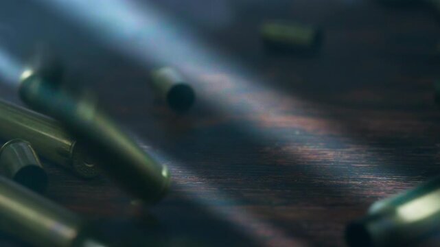 Close-up of rifle and pistol ammunition falling onto a surface amid cinematic smoke, conveying danger, military power, war and the destructive nature of armed conflict.