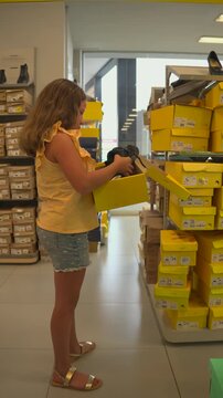 ni&ntilde;a adolescente en una tienda de zapatos escogiendo y eligiendo zapatos escolares para la escuela decidiendo cual le gusta para comprar los de moda ni&ntilde;a de compras feliz 