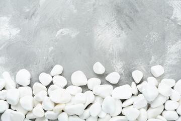 White pebble stones on concrete background, top view © Liami