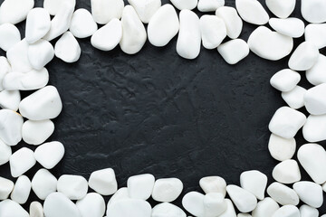 White pebble stones on concrete background, top view © Liami