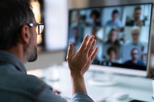 Man Waving Hello During Virtual Conference Call Meeting with Colleagues Online