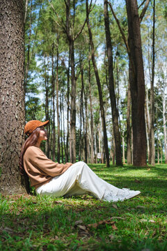 Vertical portrait image of a woman sitting and relaxing in the park