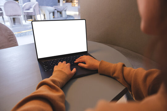 Mockup image of a woman working and typing on laptop computer with blank white desktop screen
