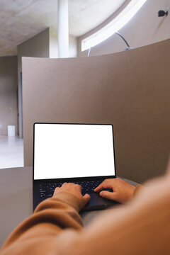 Vertical mockup image of a woman working and typing on laptop computer with blank white desktop screen