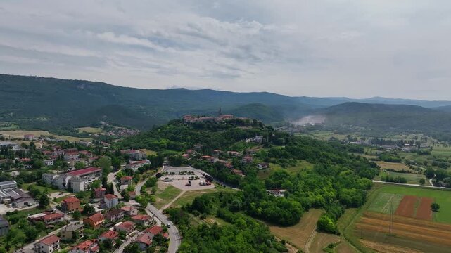 aerial drone view of Buzet historic medieval town in Istria Croatia at early summer showing old stone buildings, hilltop settlement, surrounding forests and green valley landscape