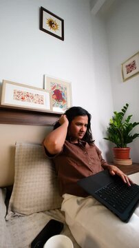 Stressed woman working from home on laptop from dramatic low angle