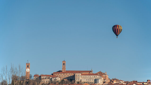 Mondov&igrave;, Piemonte, Italia -  5 Gennaio 2019. Panorama della cittadina piemontese, Italia, nel cielo azzurro si levano mongolfiere colorate.