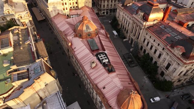 Aerial drone view of Palatul Pinacotecii, also known as Dacia-Romania Palace, in Bucharest&rsquo;s Old Town, surrounded by historic rooftops and streets at golden hour.
