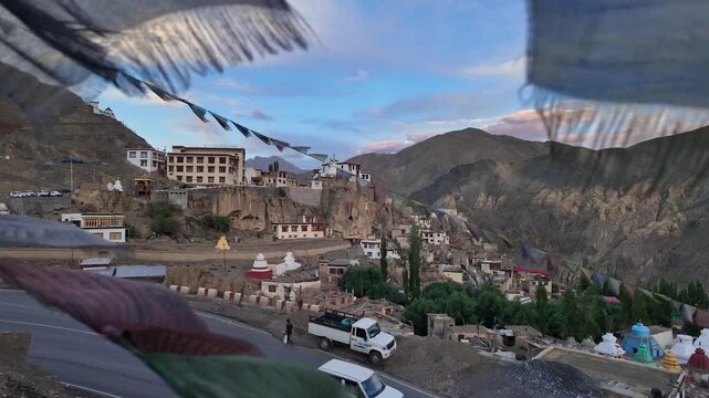 Lamayuru, India: Footage of cars in mountain road and famous Tibetan Buddhism Lamayuru monastery or Yuru Gompa in Ladakh Himalayan mountains in India. Taken with backward motion through prayer's flags