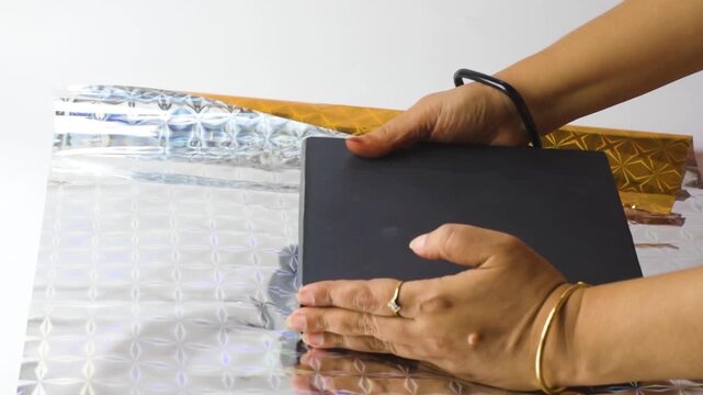 Gift Wrapping a Black Box with Shiny Gold Holographic Paper