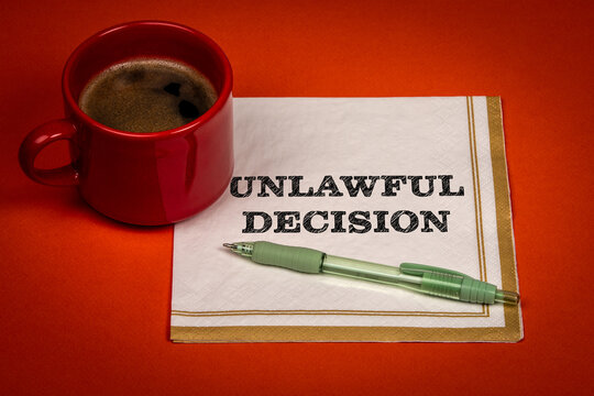 UNLAWFUL DECISION Message Displayed Beside a Coffee Cup and Pen