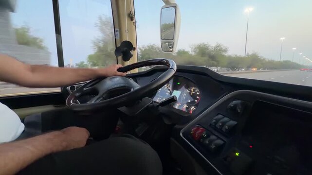 A clean, modern coach cockpit shows its controls and wide windshield view while smoothly cruisi