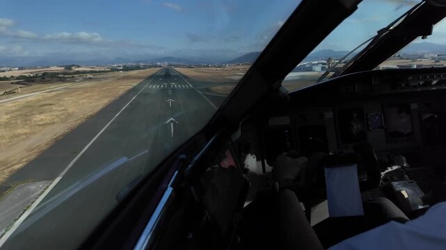 An immersive pilot eye view taken from inside a jet airplane cockpit in a real time landing to short and complex Pamplona airport runway 33, with a view of Pilot hand on the flight controls. 4K shot.