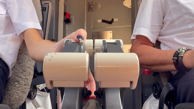 Close-p, low angle view of the hand of a female pilot on the engine throttle lever starting up the right engine