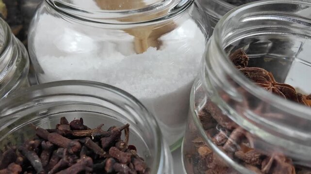 Different shapes and sizes of empty glass jars filled spice and herb for storage, reuse of glass jars, kitchen organization