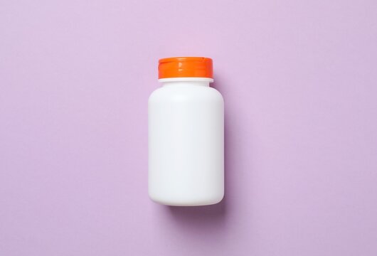 Medicine bottle on violet background