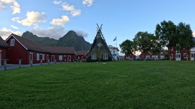 Ultra wide view of traditional Sami lavvu tent and red cabins in Svolvaer Lofoten