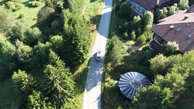 Aerial Top Down Shot of White Camper Van Driving along Mountain Forest Roa
