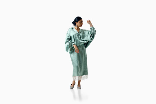 Fashionable woman models mint green coat dress full-body on white. Concept of pastel style, contemporary femininity, elegant outerwear and wardrobe inspiration.