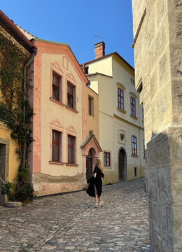 Woman exploring historic streets of Kutna Hora with St. Barbara Cathedral in background, Czech Republic travel concept