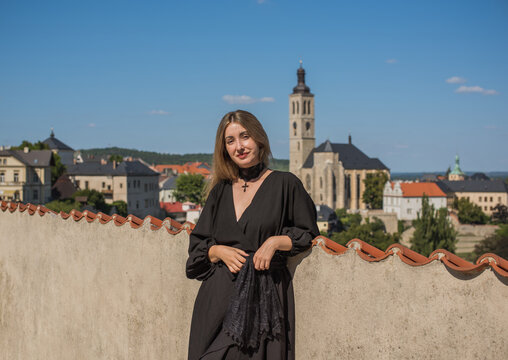 Woman exploring historic streets of Kutna Hora with St. Barbara Cathedral in background, Czech Republic travel concept