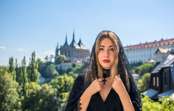 Woman exploring historic streets of Kutna Hora with St. Barbara Cathedral in background, Czech Republic travel concept