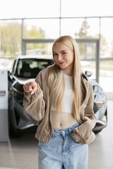 Fototapeta premium Young woman pointing finger, choosing new car