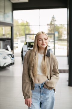 Young woman planning future car purchase at dealership