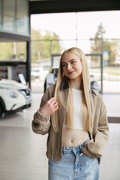 Young woman considering new car purchase in dealership
