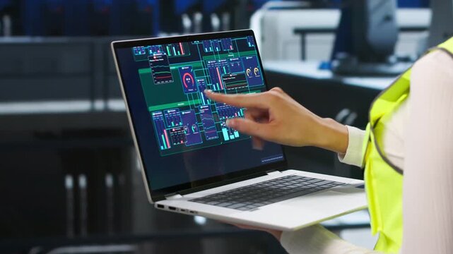 Engineer Carefully Inspects Power Plant Engine Using Laptop