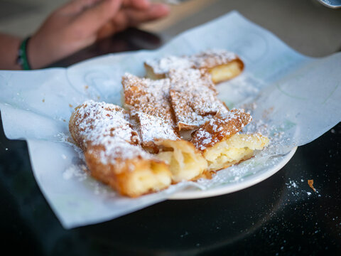 Traditional Greek bougatsa pastry with crispy phyllo and custard cream filling, dusted with sweet icing sugar and cinnamon, served in bite sized pieces, a famous authentic Thessaloniki breakfast.