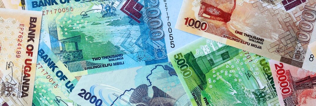 Ugandan shilling money bills in pile on table. Uganda UGX currency cash close up